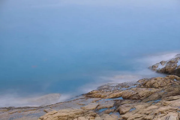 Rocky sea coast and blurred water in shek o — Stock Photo, Image