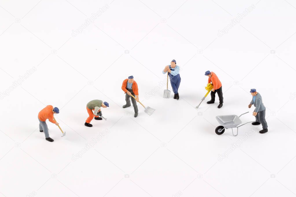 Miniature workers isolate on white background.