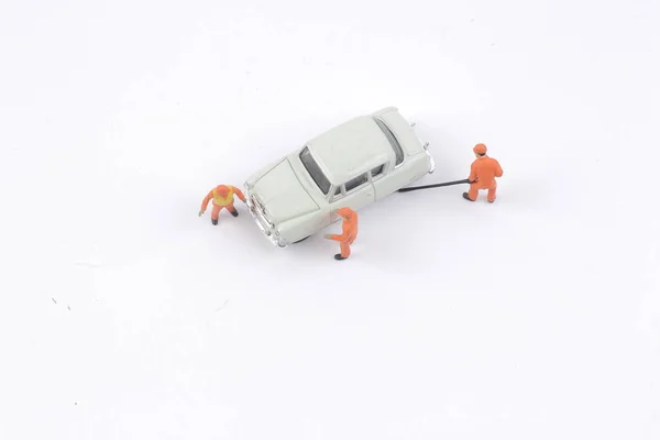 Mecánica en miniatura trabajando en un coche — Foto de Stock