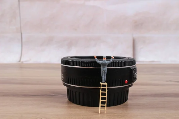 Woker miniatura limpando a lente — Fotografia de Stock