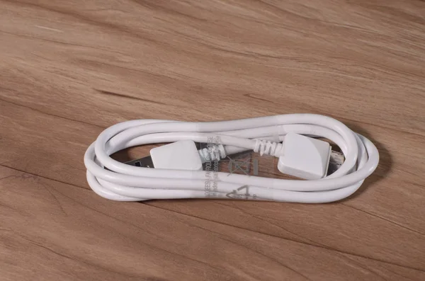 Cable USB en mesa de madera . — Foto de Stock