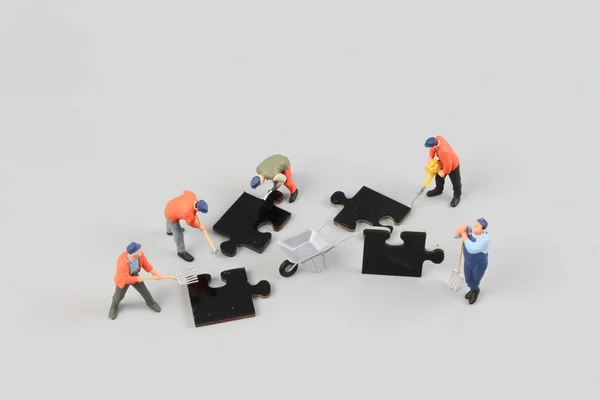 Menschen arbeiten zusammen und halten Puzzleteile hoch — Stockfoto