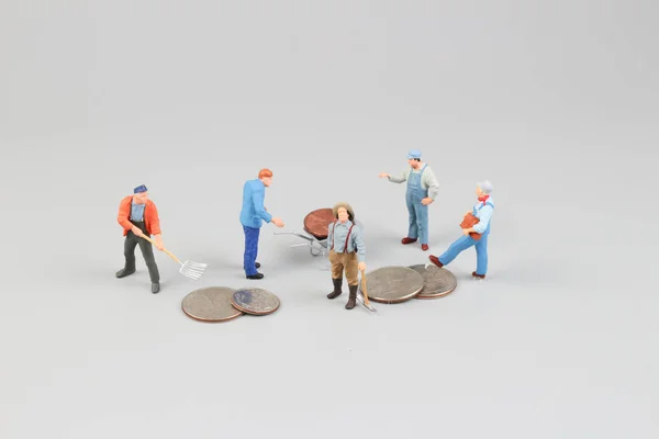 Os Mini trabalhadores coletam moedas no local — Fotografia de Stock