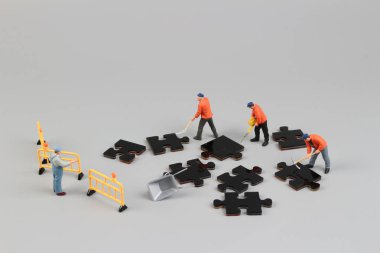 puzzle parçaları üzerinde çalışan heykelcik