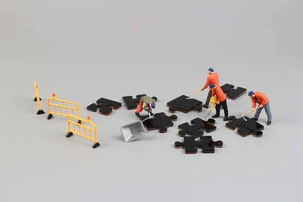 Worker figurine on puzzle pieces — Stock Photo, Image