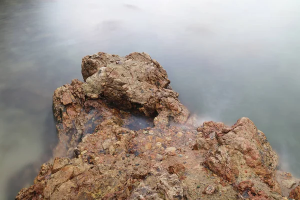 Κύματα μαστίγιο γραμμή επιπτώσεις βράχο στην παραλία — Φωτογραφία Αρχείου