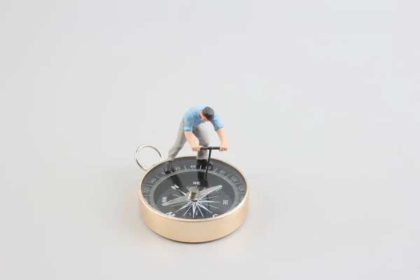 Mini figur som står på en kompass — Stockfoto