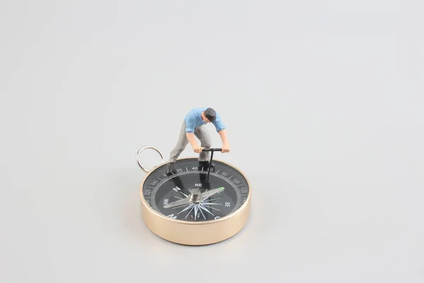 Mini figure standing on a compass — Stock Photo, Image