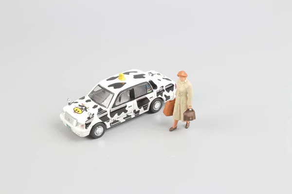 Pequeño de juguete taxi con la figura del viajero — Foto de Stock