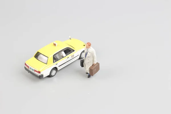 Pequeño de juguete taxi con la figura del viajero — Foto de Stock