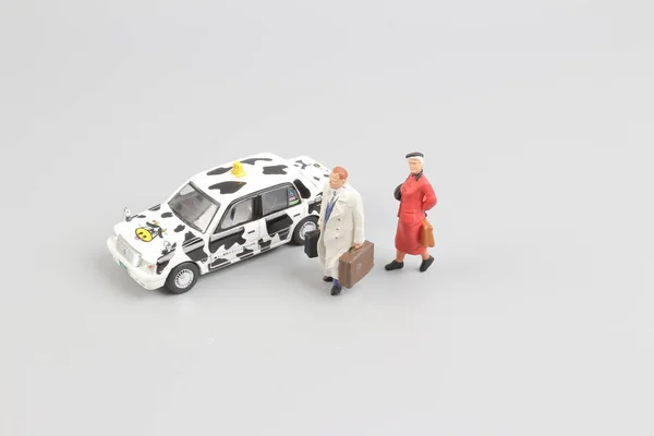 Pequeño de juguete taxi con la figura del viajero — Foto de Stock