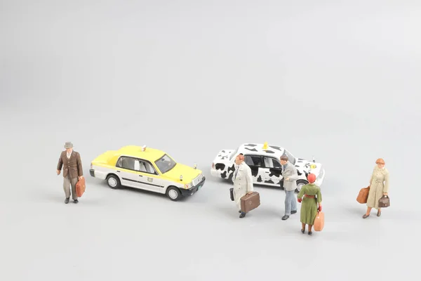 Pequeño de juguete taxi con la figura del viajero — Foto de Stock
