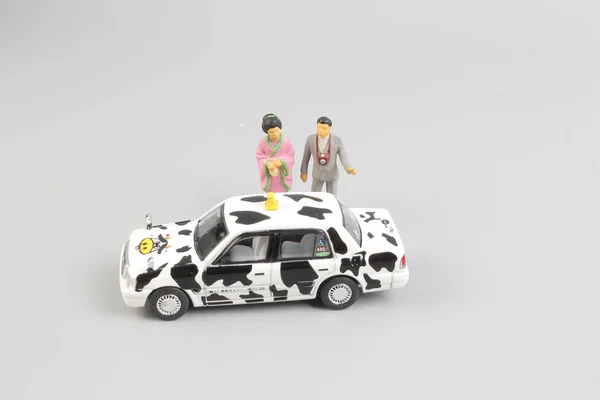 Minúsculo de táxi de brinquedo com a figura do viajante — Fotografia de Stock
