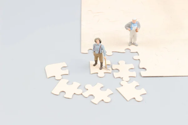 Businessmen collaborate holding up jigsaw puzzle pieces — Stock Photo, Image