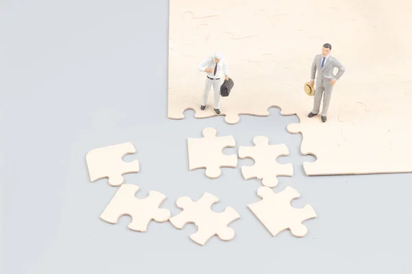 Business men collaborate holding up jigsaw pieces puzzle — стоковое фото