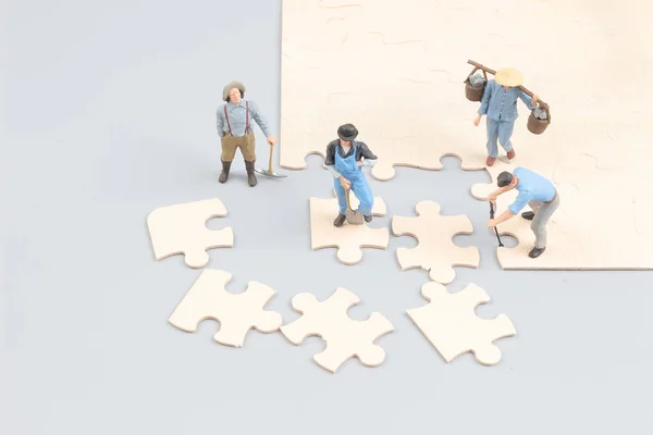 Menschen arbeiten zusammen und halten Puzzleteile hoch — Stockfoto