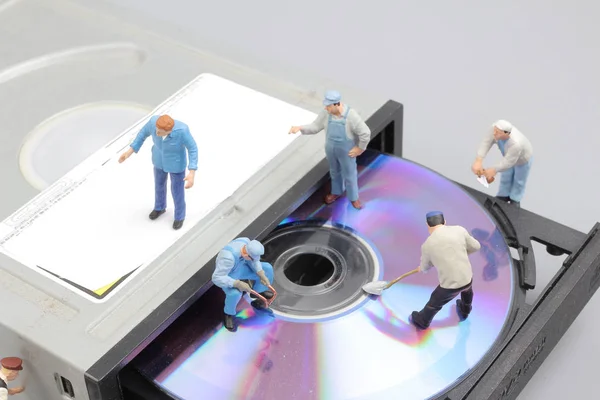Miniatur insinyur dan pekerja tetap untuk membersihkan rom CD — Stok Foto