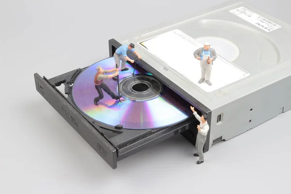 ミニチュア エンジニアおよび労働者の Cd-rom をきれいに固定 — ストック写真