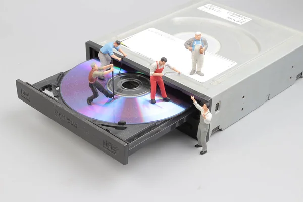 Мініатюрний інженер і працівник зафіксований для чищення CD-рома — стокове фото