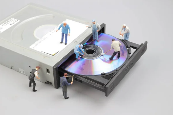Мініатюрний інженер і працівник зафіксований для чищення CD-рома — стокове фото