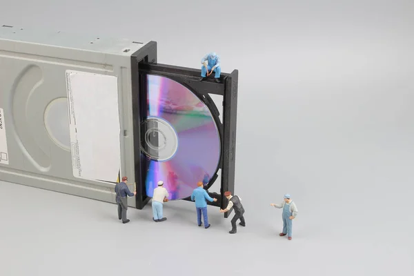 Міні-інженер і працівник зафіксований для чищення CD-рома — стокове фото