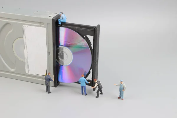 Mini engineer and worker fixed to clean CD rom — Stock Photo, Image