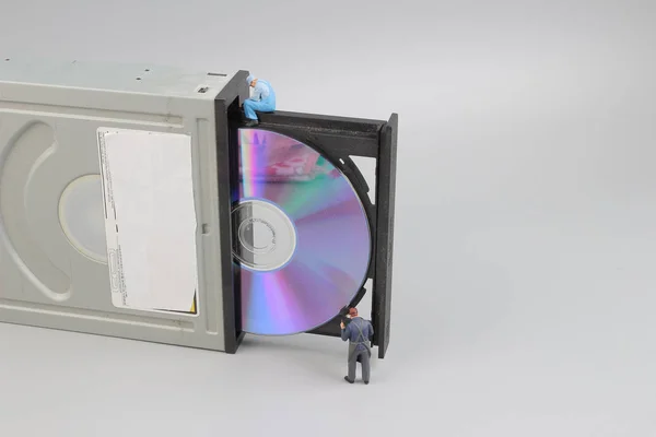 Мини-инженер и рабочий чистили компакт-диск — стоковое фото