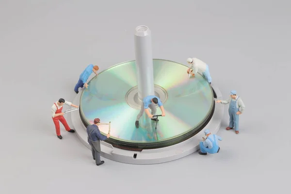 Minifigurka pracovníka kolem disku — Stock fotografie