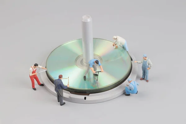 Minifigurka pracovníka kolem disku — Stock fotografie