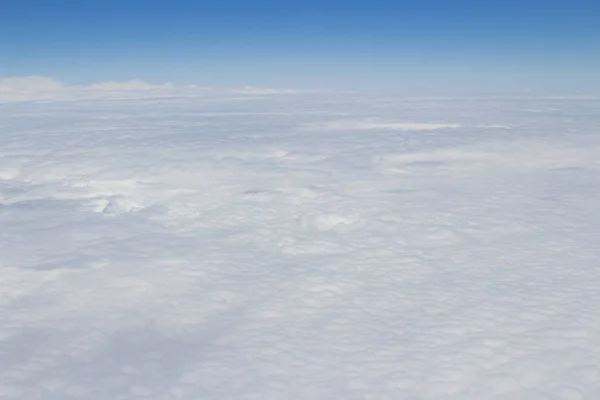 Blauwe hemel hoog uitzicht vanaf vliegtuig wolken vormen — Stockfoto