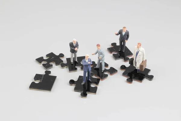 Geschäftsleute arbeiten zusammen und halten Puzzleteile hoch — Stockfoto