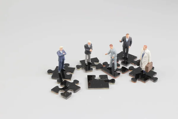 Uomini d'affari collaborano tenendo in mano pezzi puzzle — Foto Stock