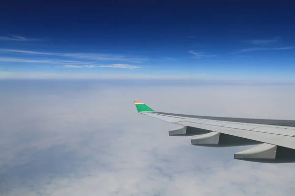 Plan vinge flyger ovanför molnen — Stockfoto