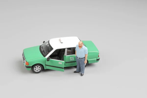 Kleine figuur met groene taxi bij hk — Stockfoto