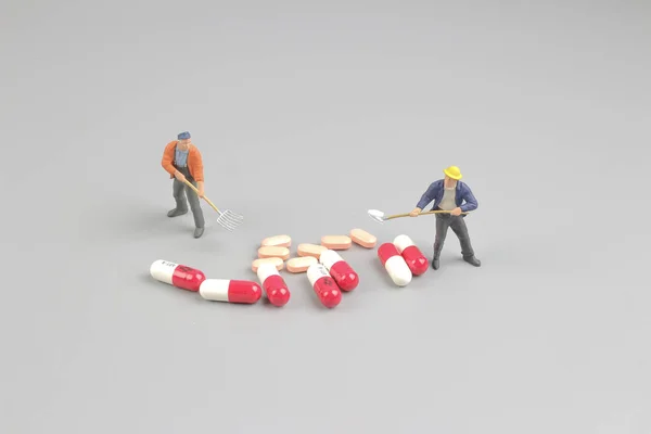 El trabajador de la figura delante de las pastillas — Foto de Stock