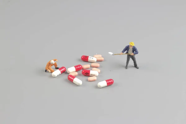 El trabajador de la figura delante de las pastillas —  Fotos de Stock