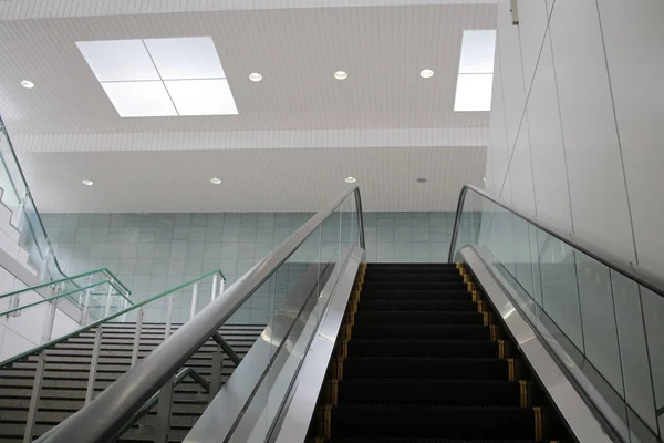 Monter dans l'escalier roulant moderne dans la gare — Photo