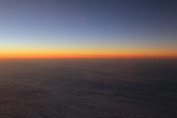 มุมมองที่น่าทึ่งจากเครื่องบินบนท้องฟ้า ดวงอาทิตย์ตกและเมฆ — ภาพถ่ายสต็อก