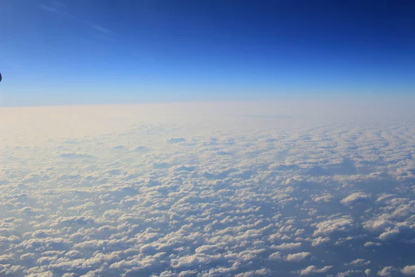 Pohled z okna letadla nad cloud a modrá obloha — Stock fotografie