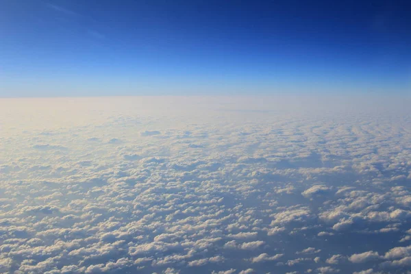 Pohled z okna letadla nad cloud a modrá obloha — Stock fotografie