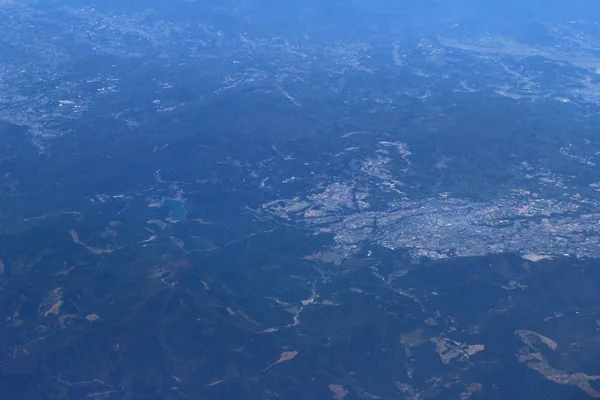 Вид с воздуха на город через окно самолета — стоковое фото
