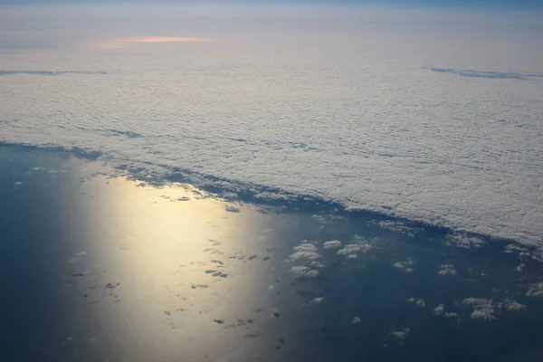 Вид над землей при облаках внизу — стоковое фото