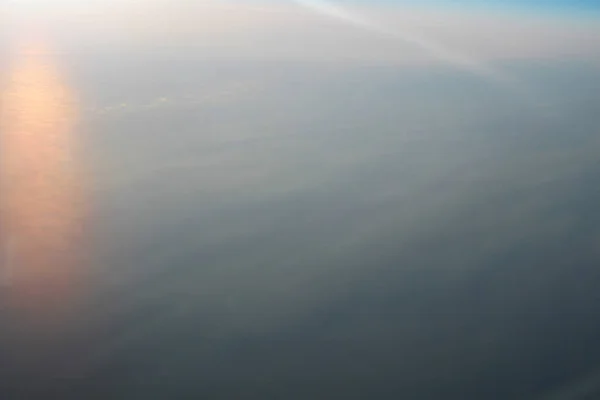 Вид над землей при облаках внизу — стоковое фото