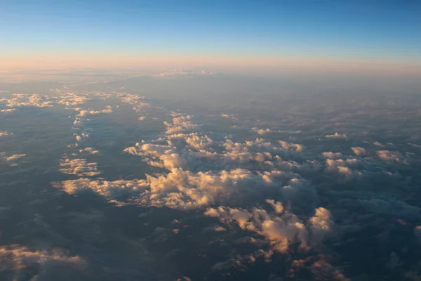 Spectaculair uitzicht van een zonsondergang boven de wolken uit vliegtuig wind — Stockfoto