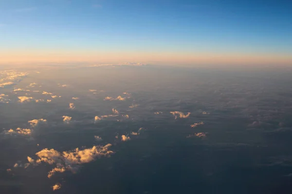 Espectacular vista de una puesta de sol sobre las nubes desde el viento del avión — Foto de Stock