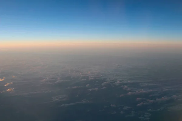 Видовищний вид на захід сонця над хмарами від вітру літака — стокове фото