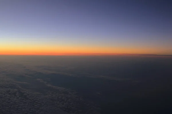 Increíble vista desde el avión en el cielo, el sol puesta del sol y las nubes —  Fotos de Stock