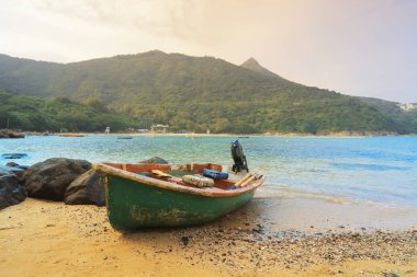 kumsalda güneş doğarken balıkçı teknesi