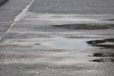 Şehirdeki kaldırımda yağmur birikintileri