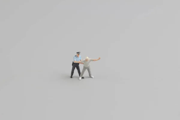 Mini figura di poliziotto con manette a mano — Foto Stock
